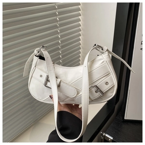Detailed close-up of a white crescent shoulder bag with metallic buckle decorations