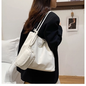 Detail of minimalist white faux suede tote bag with side pouch and HYLL ZZ lettering
