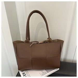 Detail view of deep brown large woven leather tote bag with stylish tie closure