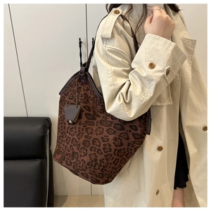 Dettaglio borsa shopper leopardata con cinturini in pelle marrone e ciondolo a cuore