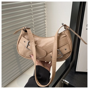Detail of a chic beige underarm bag with silver buckle straps and a smooth PU leather finish