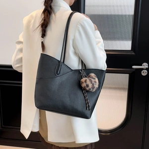 Sac seau noir chic avec breloque cœur léopard porté comme un sac à bandoulière élégant