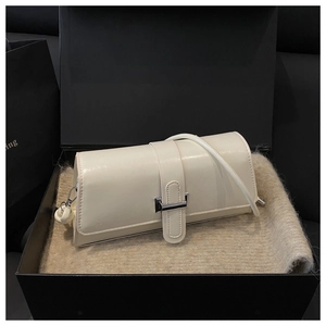 Detail of creamy white leather underarm bag with silver buckle in a gift box