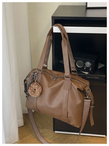 Gros plan sur le sac fourre-tout en cuir marron avec bandoulière large à motifs