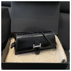 Glossy black patent leather shoulder bag with silver hardware in a luxury gift box