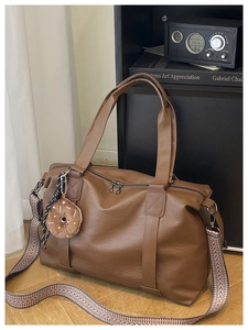 Détail du sac cabas en similicuir marron avec bandoulière chevron et bijou de sac