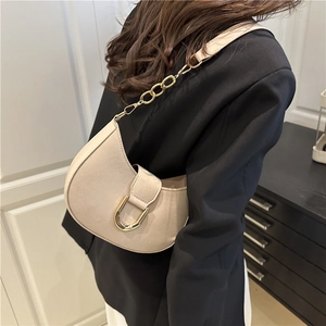 Borsa a spalla beige a mezzaluna con fibbia dorata e tracolla indossata da una modella