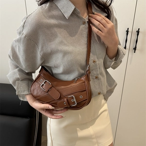 Vintage brown leather shoulder bag with motorcycle buckles and sleek crescent moon shape