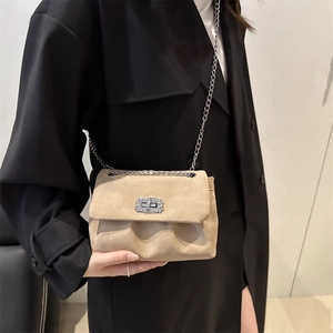 Beige suede crossbody bag with sparkling rhinestone twist lock and silver chain strap