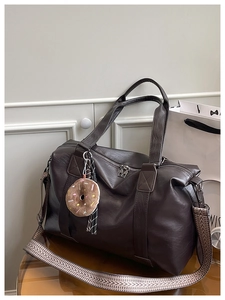 Détail du sac cabas marron foncé avec charme donut et bandoulière tissée géométrique