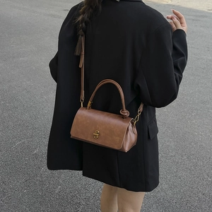 Brown retro leather handbag with knot handle and gold buckle, crossbody style
