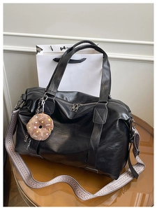 Détail du fourre-tout noir en cuir PU avec bandoulière tissée et bijou de sac