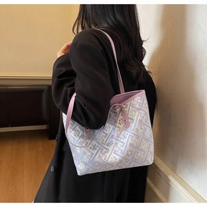 Detail of purple tote bag with white floral jacquard pattern worn by a model