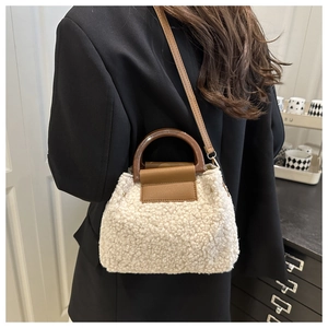 Détail du sac seau en polaire beige avec poignée en cuir marron et bandoulière