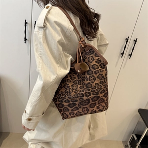 Borsa tote leopardata con manici in pelle indossata con un trench beige alla moda
