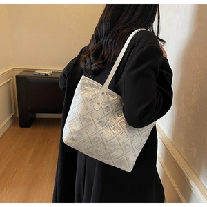 Detailed close-up of a white woven tote bag with intricate floral and geometric patterns