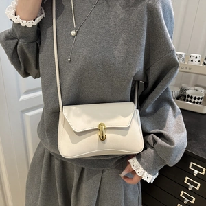 Piccola borsa a tracolla bianca minimalista con elegante chiusura girevole in metallo dorato