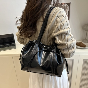 Glossy black patent leather shoulder bag with drawstring bow detail for women's fashion