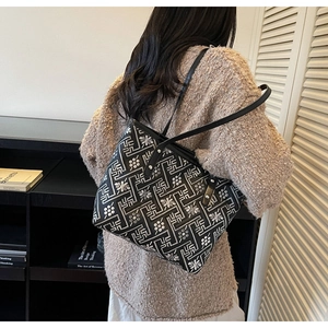 Detail view of large tote bag with white geometric patterns and slim black shoulder straps