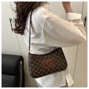 Close-up of vintage brown monogram shoulder bag with leather G-logo detail