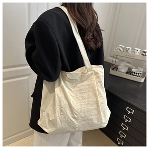 Détail du sac cabas ivoire avec tissu plissé et écusson avec lettrage FASHION