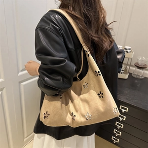 Retro khaki suede hobo bag with floral cutout design shown on shoulder for daily style