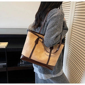 Detailed side view of a vintage patchwork tote bag in camel and dark brown leather