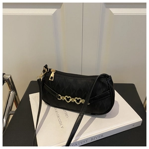 Dettaglio borsa a spalla in jacquard nero con catena a cuore dorata e trama con motivo M
