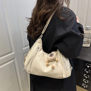 Minimalist beige shoulder tote bag in soft leather with cute plush ball charm accessory