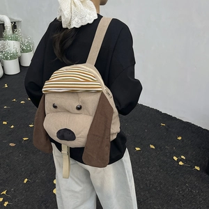 Süßer Kord-Rucksack mit Cartoon-Hund für Kinder, getragen von einem Modell im Freien