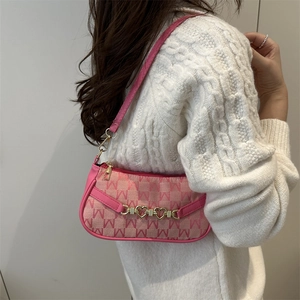 Borsa a spalla in tela rosa con stampa di lettere e catena a cuore indossata su maglione
