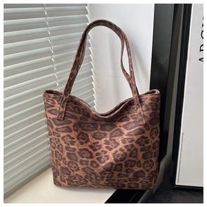 Close-up of a stylish leopard print tote bag placed on a windowsill in natural sunlight