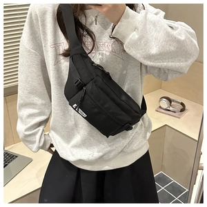 Detailed view of black nylon chest bag with adjustable strap on model for causal wear