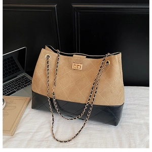 Dettaglio della borsa tote in pelle scamosciata kaki e pelle trapuntata nera con catena