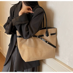 Grand sac cabas minimaliste en daim kaki porté avec une sangle décorative noire