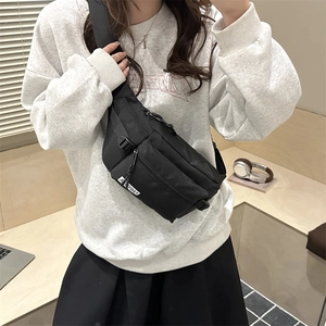 Minimalist black nylon crossbody sling bag with adjustable strap and multiple zip pockets