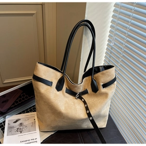 Détail du sac cabas beige avec bandoulières noires et boucle de ceinture décorative