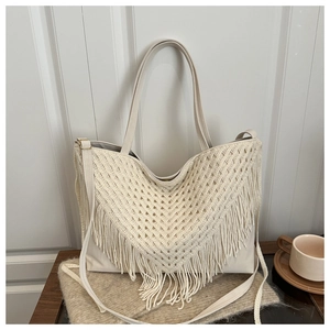 Detail of bohemian cream woven tote bag with long v-shaped tassels and adjustable strap