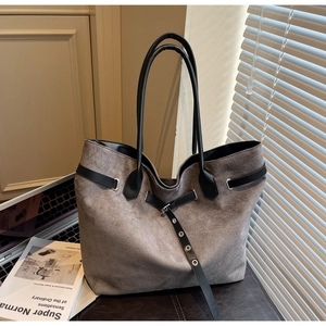 Détails de ce sac cabas en daim taupe avec anses en cuir noir et ceinture décorative à œillets
