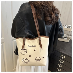 Close-up of contrast tote bag with cute cat prints and brown leather shoulder strap
