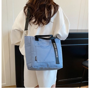 Blue high-capacity canvas tote bag with adjustable shoulder strap and logo details