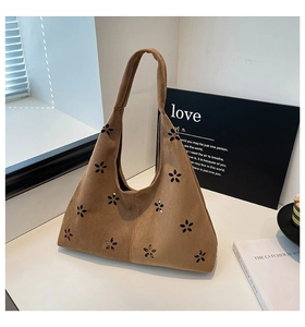 Close-up of brown suede tote bag featuring intricate laser-cut floral patterns and texture