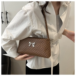 Dettaglio della borsa a spalla marrone monogramma con fibbia a fiocco argento