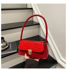 Dettaglio borsa in pelle PU rossa con trama a coccodrillo e chiusura in metallo dorato