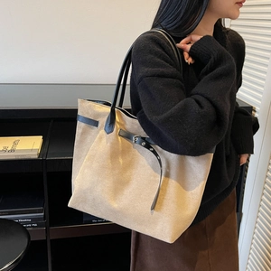 Minimalist large beige suede tote bag with black leather straps and metal buckle