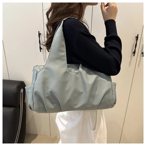 Dettaglio della borsa tote azzurra stropicciata con tasca laterale e consistenza morbida