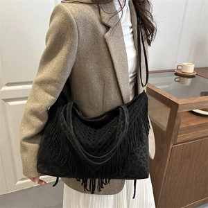 Black tassel tote bag with leopard print details and detachable strap shown on model