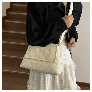 Detail der cremefarbenen Stepptasche mit weicher Wattierung und praktischem Klappverschluss