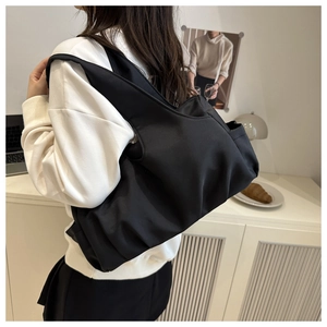 Elegante borsa tote in nylon nero a pieghe portata a spalla in un interno curato