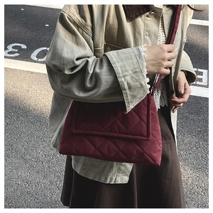 Detail der weinroten Stepptasche mit Rautenmuster an einem Straßenmodell